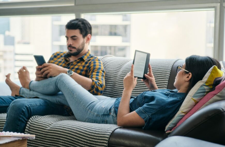 Couple Reading Ebook With Ereader On Couch