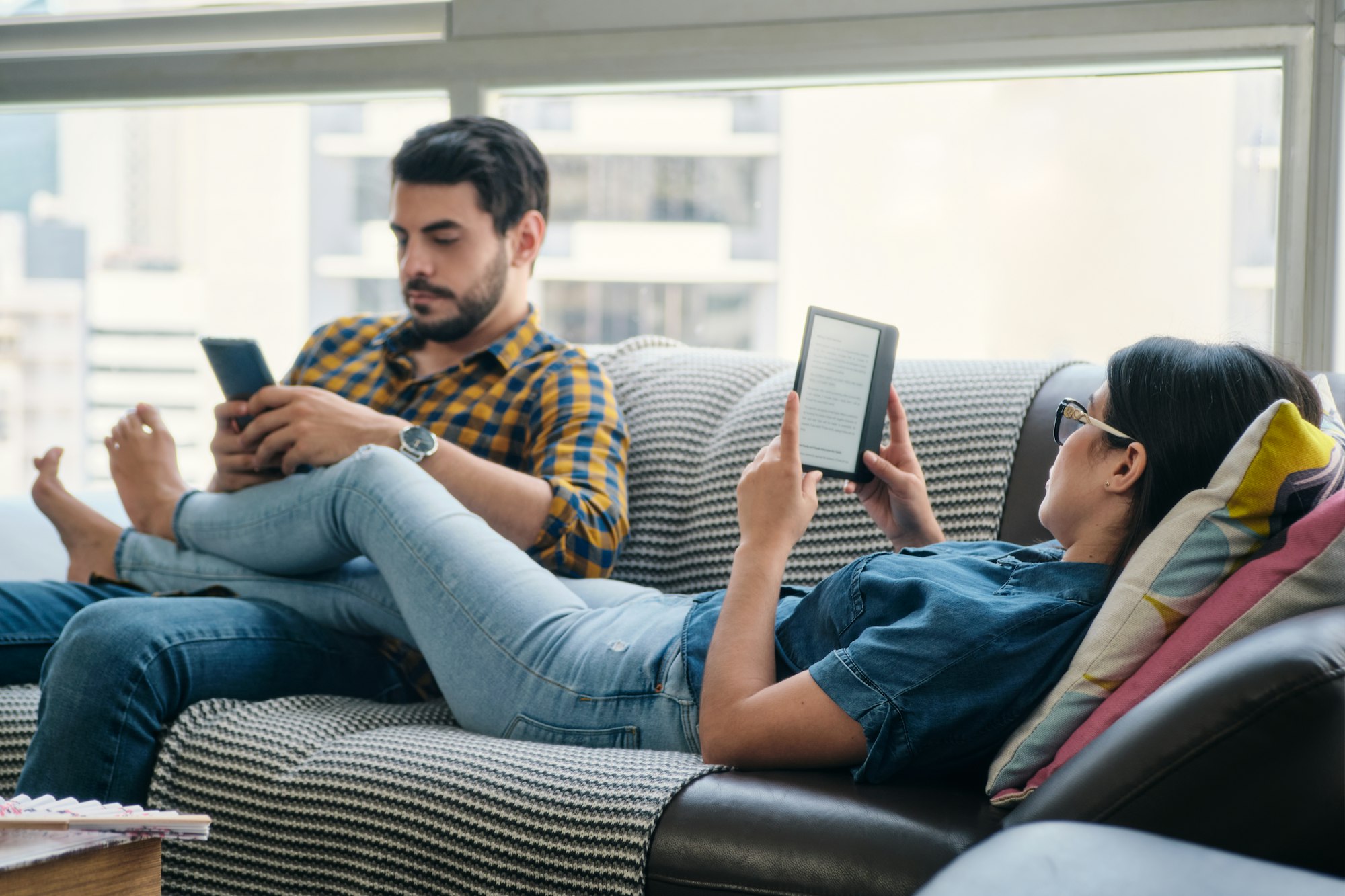 Couple Reading Ebook With Ereader On Couch