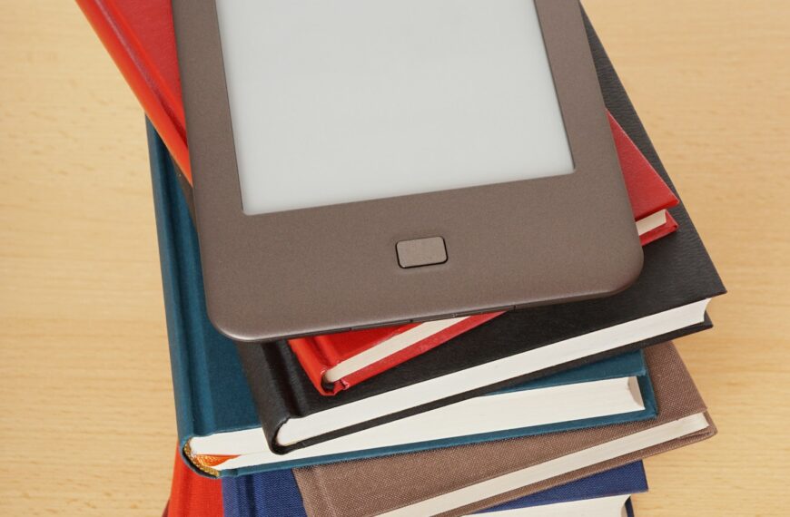 e-book or e-reader on top of pile of old books