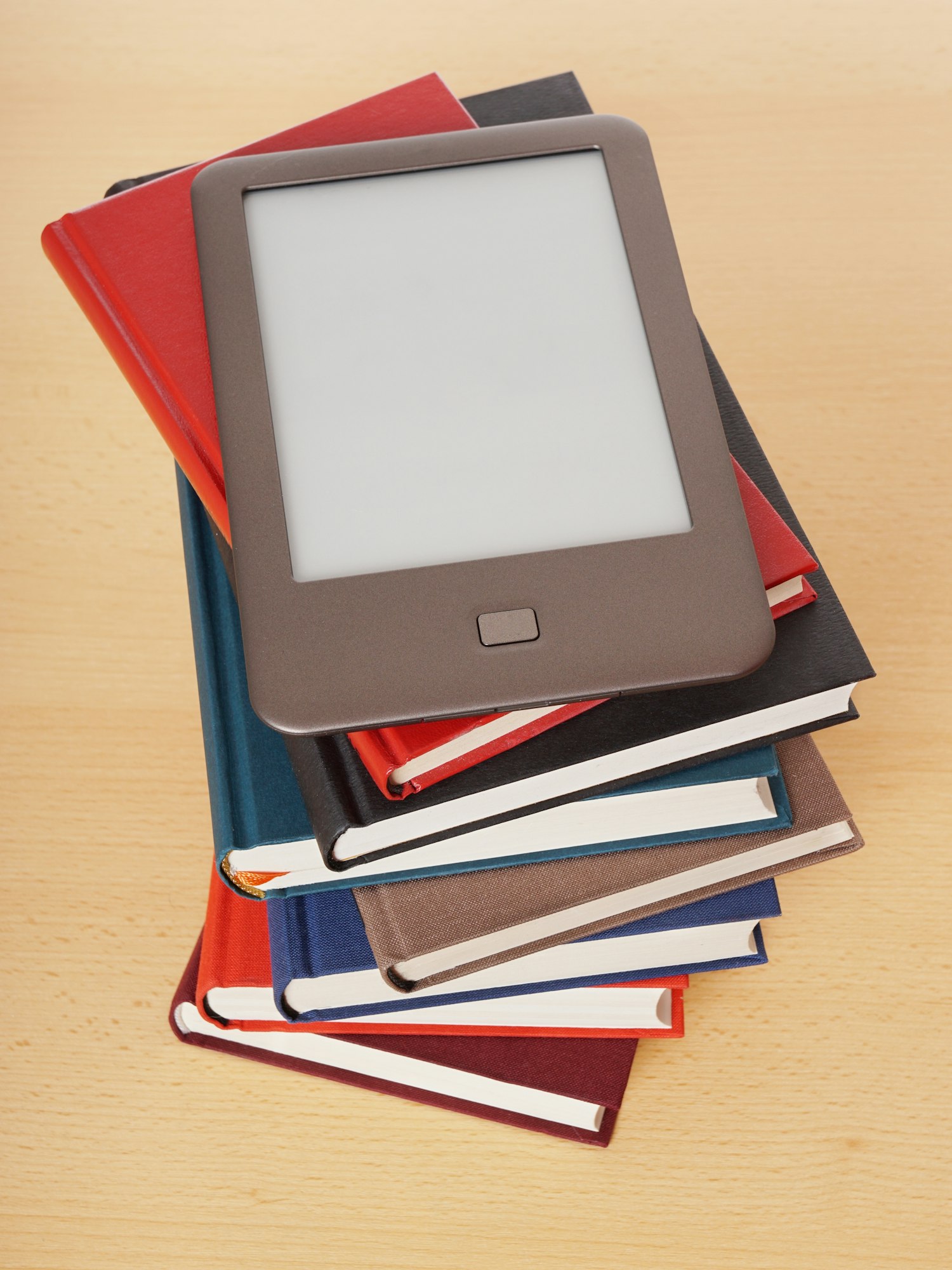 e-book or e-reader on top of pile of old books